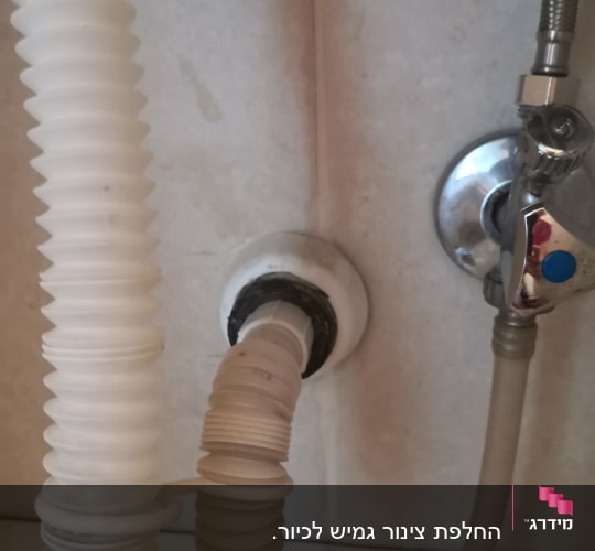 צינור גמיש מחובר לקיר עם ברז מתכת